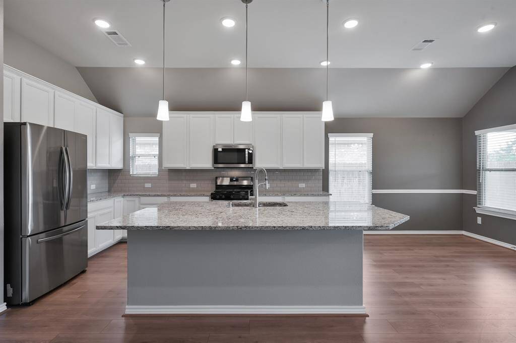 tunning, clean, & pristine kitchen with massive island.