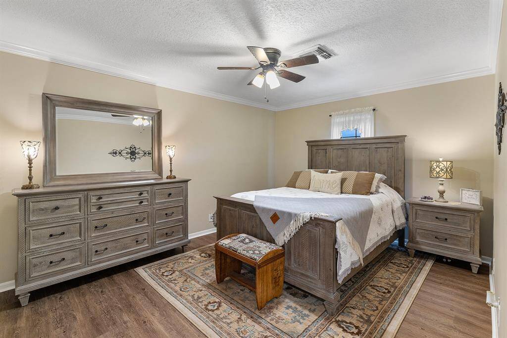 This cozy secondary bedroom features warm, neutral tones. It includes a ceiling fan, and soft lighting, creating a welcoming and comfortable atmosphere.