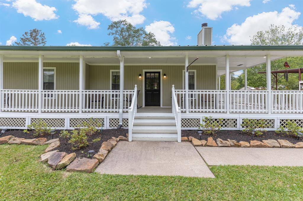 Charming single-story home with a spacious wraparound porch, perfect for relaxing outdoors. The front yard is well-landscaped with a neat walkway leading to the entrance. Ideal for those seeking a peaceful setting.