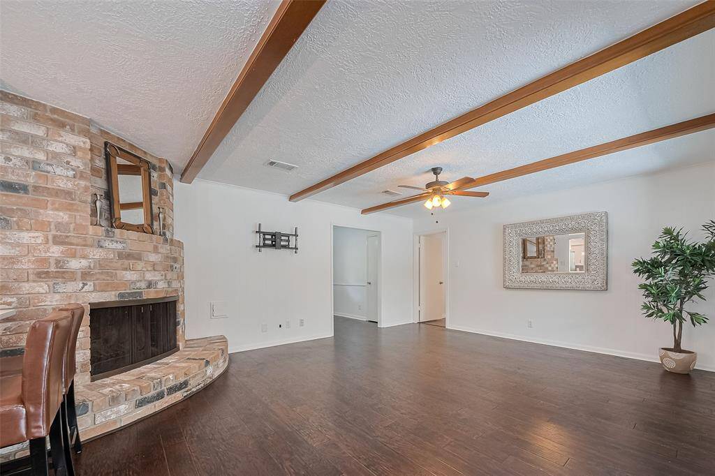 Another view of family room  with rich wood beam ceilings adding more warmth and character to the space.
