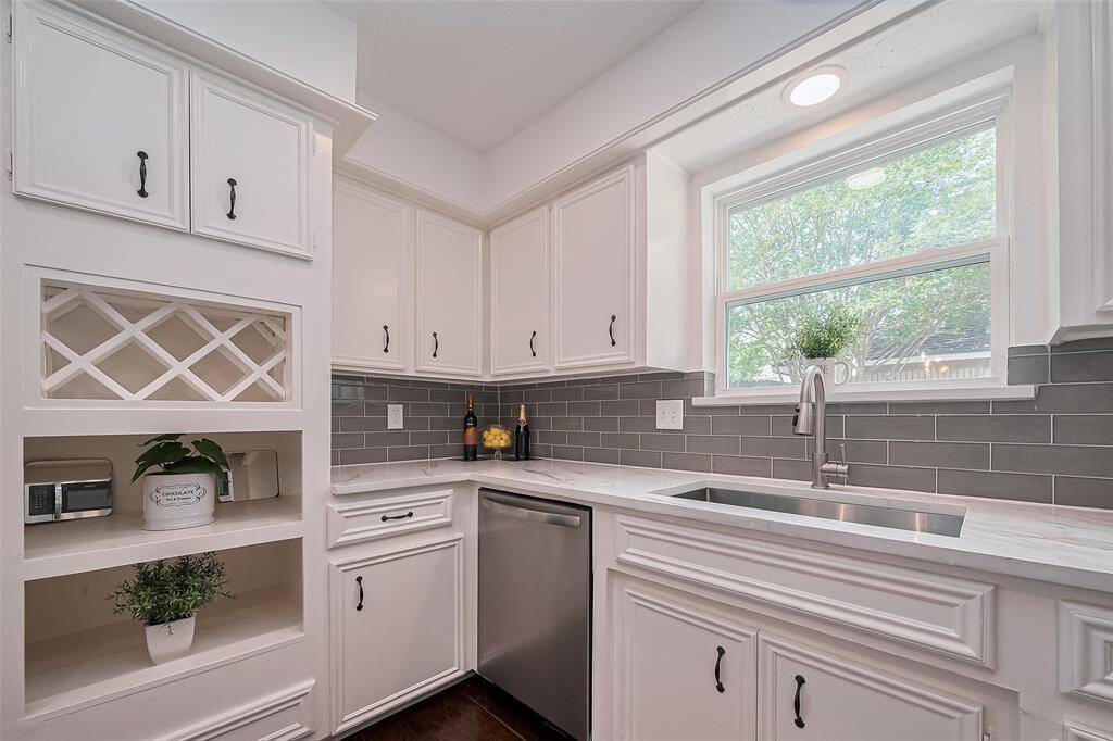 Another view of the kitchen showcasing abundant natural light and a large stainless steel appliance for convenience.