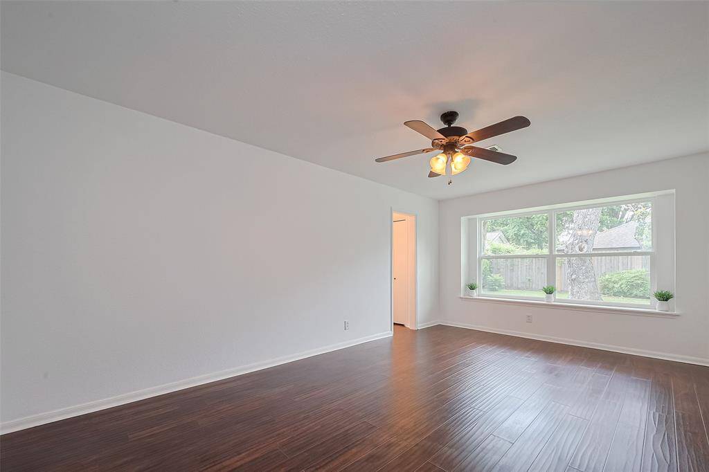 Another view of this very spacious primary bedroom with a ceiling fan.