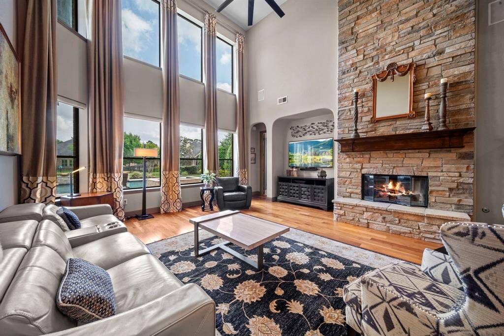The open den boasts a 2 story brick fireplace and mantle along with 2 story wall of windows that overlook the backyard