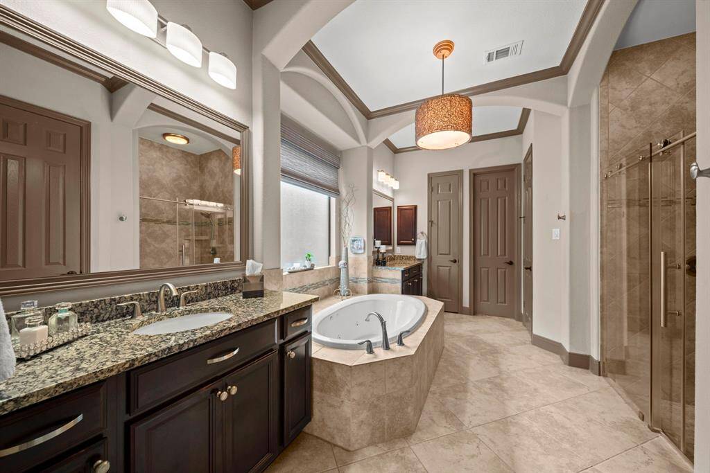 The master bath has separate vanities with granite counters, an oversized jacuzzi tub and large shower