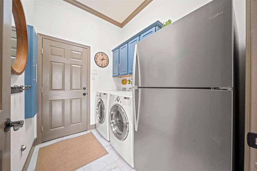 Utility room with tile floors, built in cabinets and a built in ironing board