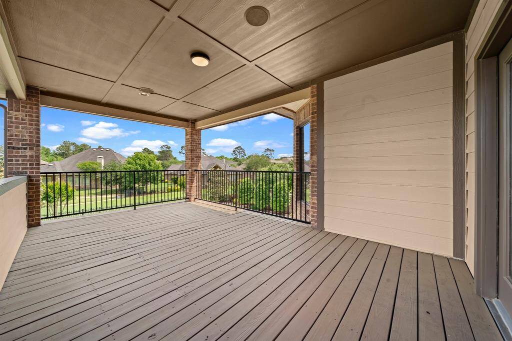 The large upstairs patio overlooks the pool, greenspace and water view