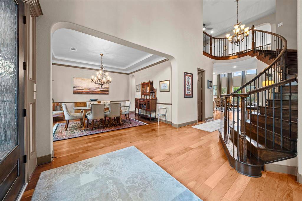 2 story entry opens to wood staircase and view through to the living room and backyard