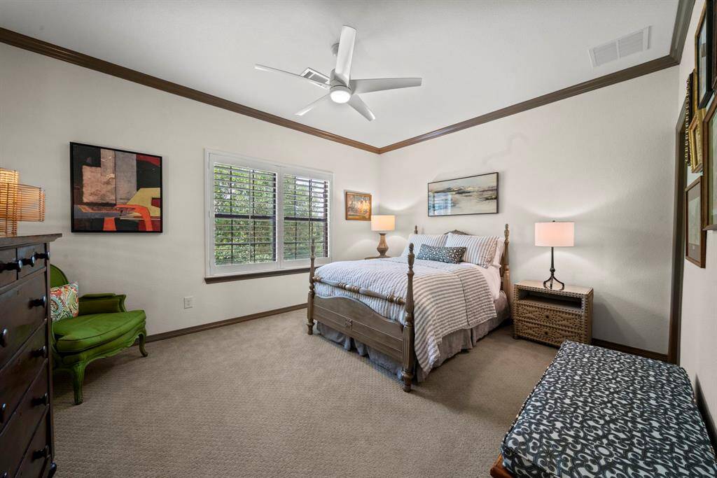 Bedroom 5 with plantation shutters, carpet and custom ceiling fan