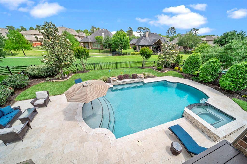 The resort style backyard with custom pool and spa, exquisite landscaping and view to the green park space with walking trails to the lake