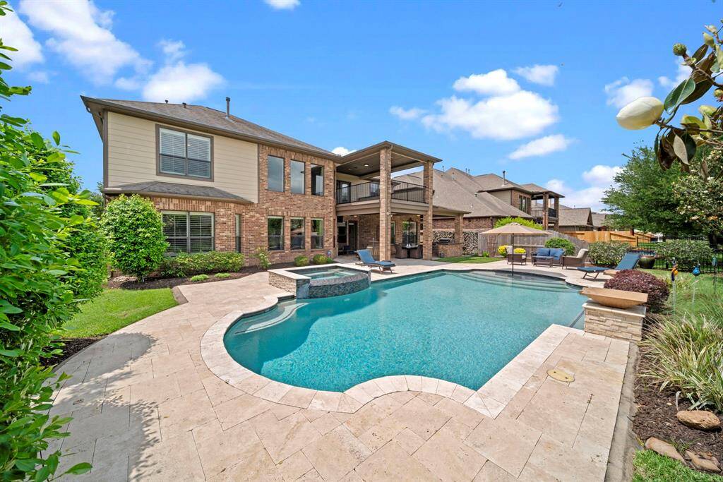 The stone decking and waterfall features add drama to the overall appeal of the backyard