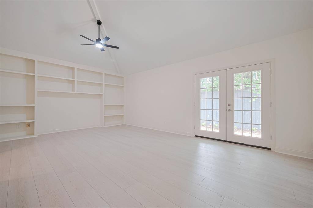 The primary bedroom is spacious with the soaring ceiling, too!  French doors provide a private entry to the back patio.