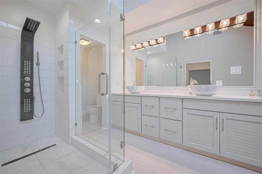The luxurious primary bathroom features a jetted tub, separate shower, and dressing bench.