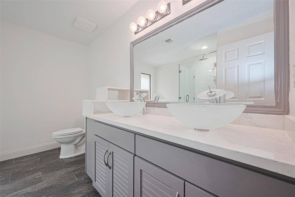 The secondary bathroom located upstairs has a double sink, separate shower, and tub.