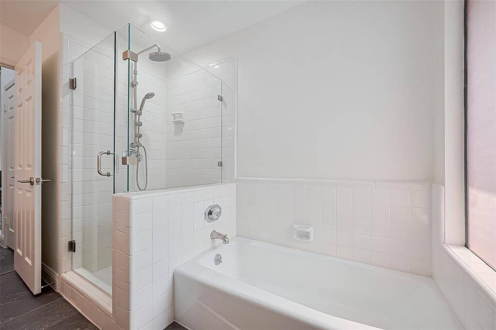 The secondary bathroom located upstairs has a double sink, separate shower, and tub.
