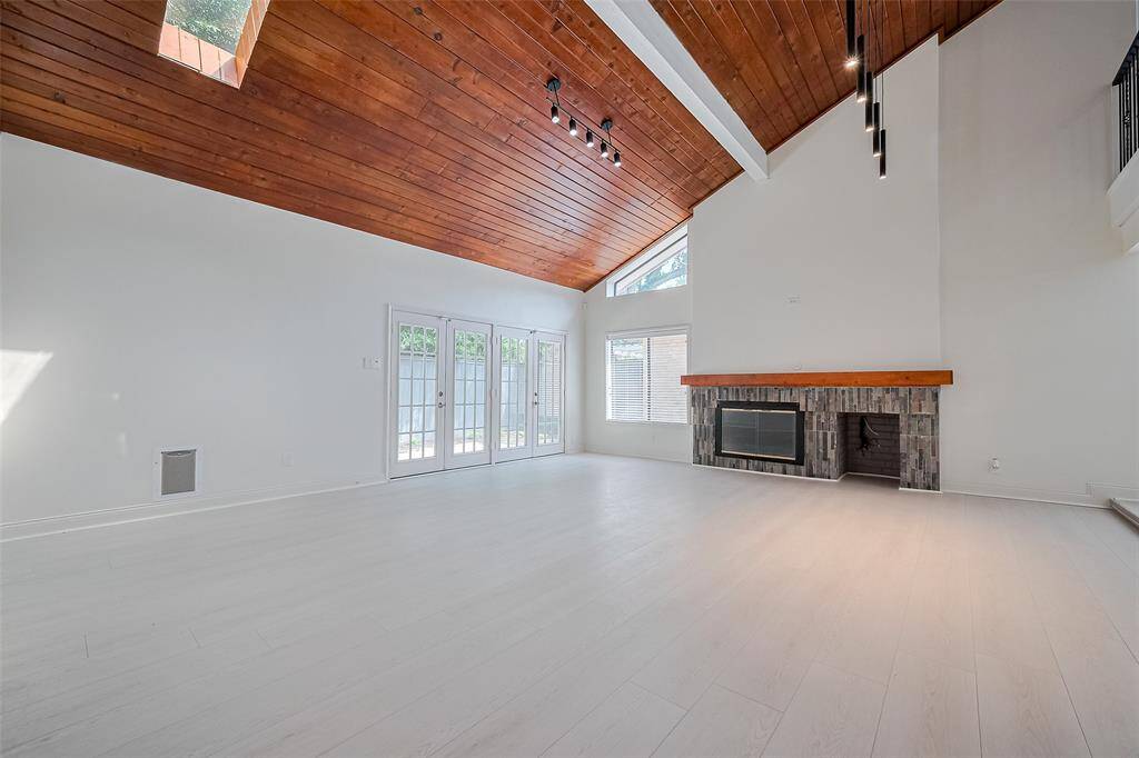 Huge living area with soaring ceilings and french doors that lead to the backyard patio.