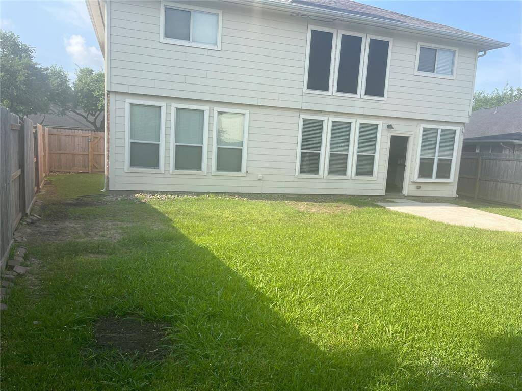 Back of home with large backyard