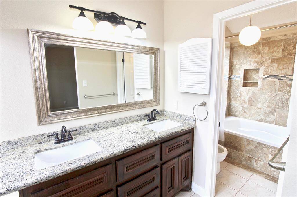 View of the updated master bath with dual sinks and granite countertops.