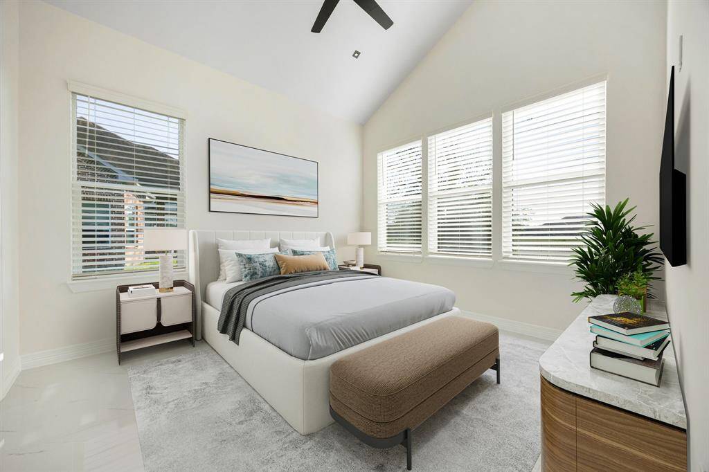 This spacious secondary bedroom is filled with natural light thanks to a wall of large windows, creating a warm and inviting atmosphere. Featuring high ceilings, neutral tones, and sleek modern finishes, it offers a serene retreat perfect for guests or family. An en suite bathroom adds an extra layer of comfort and privacy, making this space as functional as it is beautiful.