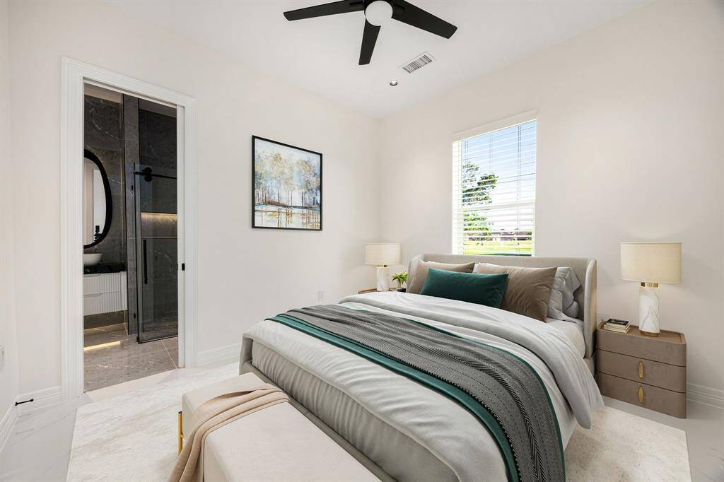 This bright and cozy secondary bedroom features clean modern lines, neutral tones, and a sleek ceiling fan. A large window fills the space with natural light, while plush carpeting and stylish finishes create a comfortable, contemporary retreat ideal for family or guests.