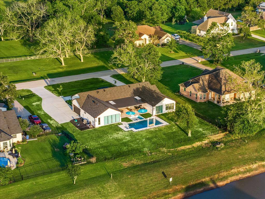 Set on a spacious waterfront lot, this stunning property offers the ultimate in outdoor living with a beautifully designed pool, expansive patio, and private yard. Located in a peaceful neighborhood with mature trees and wide open green spaces, it’s the perfect blend of luxury and tranquility.
