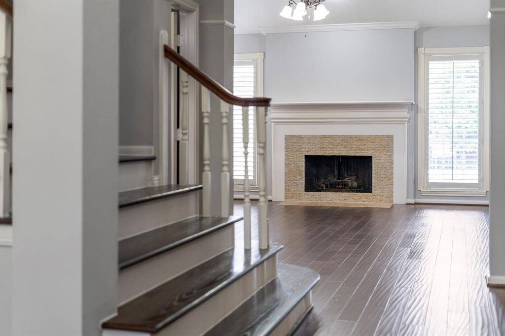 A beautifully crafted hardwood staircase serves as a striking centerpiece, adding warmth and architectural elegance to the home’s interior.