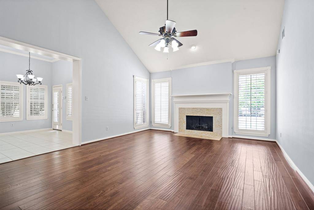 Step into the vaulted-ceiling family room, where a stacked stone fireplace creates a stunning focal point, and large windows frame serene views of the sparkling pool and private backyard oasis.