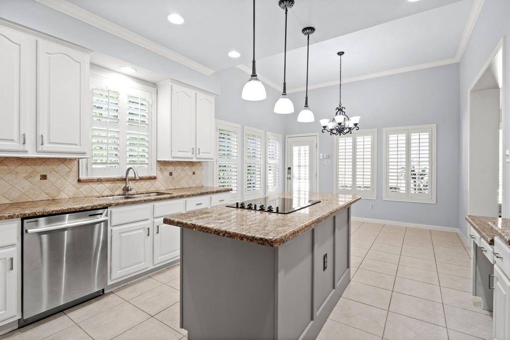 Chic pendant lighting hangs gracefully over the island, adding both style and functionality to the space.