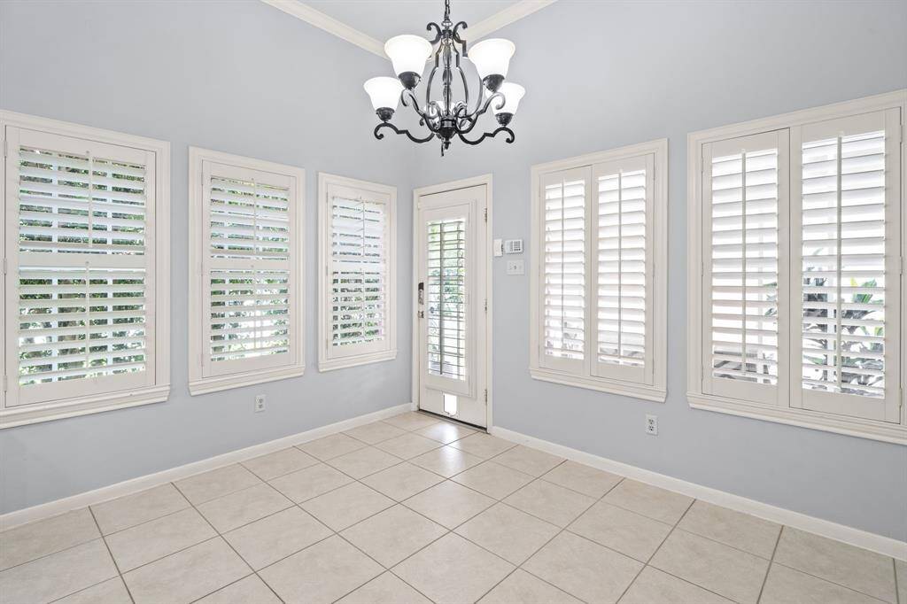 The spacious breakfast area, surrounded by windows, offers abundant natural light and easily accommodates a large table—just right for relaxed, everyday dining.