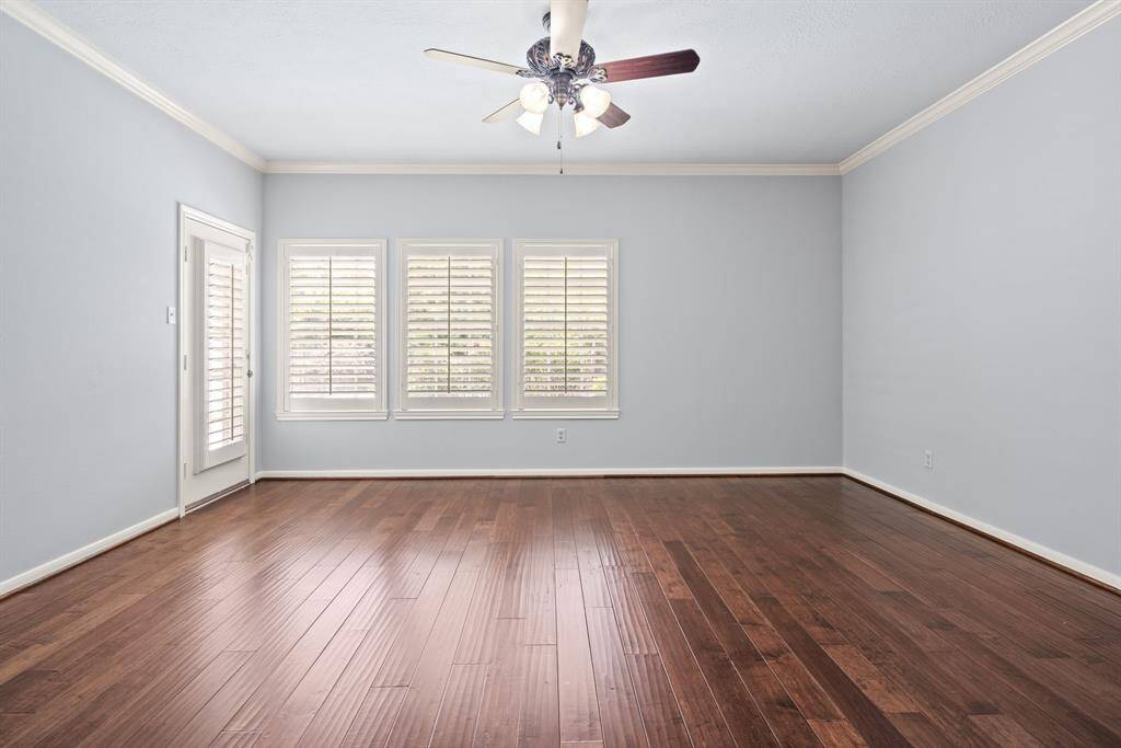 The luxurious first-floor primary suite offers serene views of the backyard and includes private access to the patio and pool area. The retreat is complete with a spacious en suite bathroom.