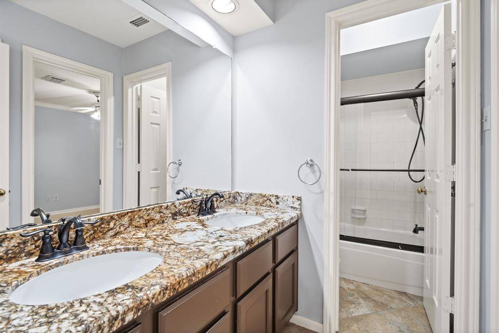 The shared bathroom, accessible from both bedrooms features a dual vanity and a private bathing area, making it ideal for multiple people to get ready in the morning.