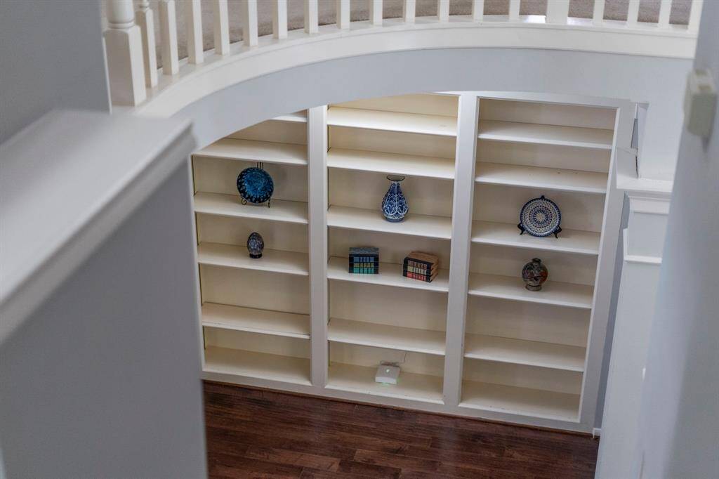 Display your art, collections, or decorative pieces in the built-in wall of shelves, offering a perfect spot to showcase your personal style and add character to the space.