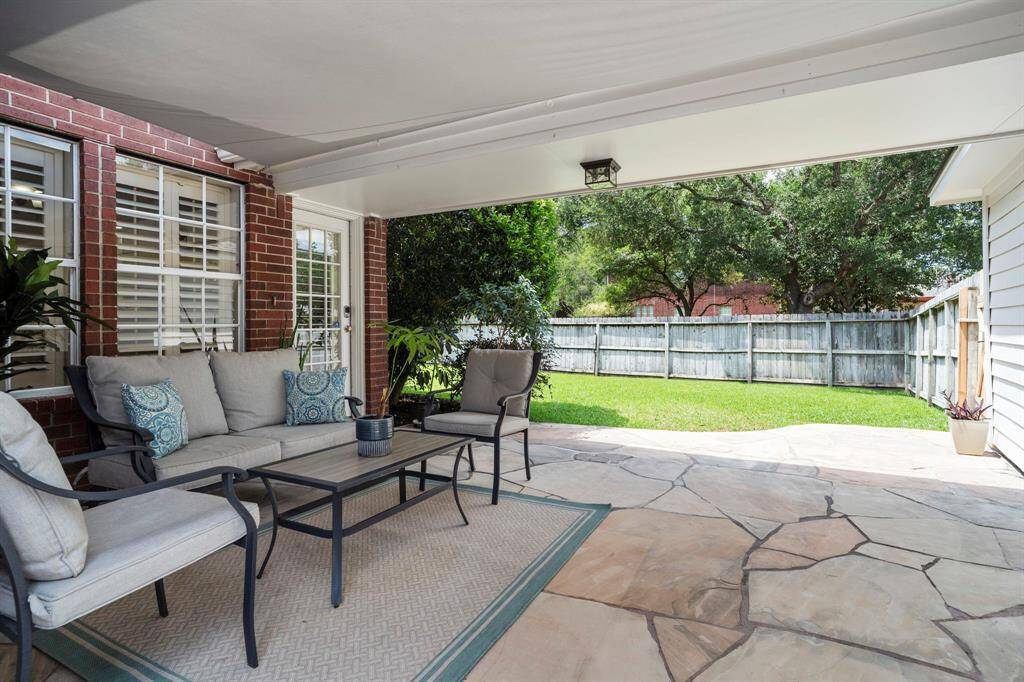 A covered patio and breezeway leading to the detached garage create a charming and intimate outdoor living space, perfect for relaxing in a sheltered setting.