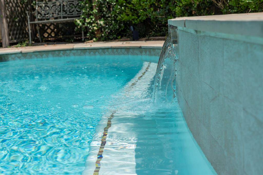Relax by the pool and enjoy the soothing sound of a serene waterfall.