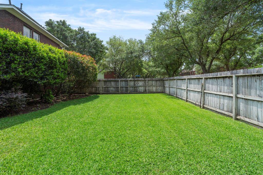 A spacious, grassy area offers plenty of room for children, pets, and outdoor activities, making it an ideal space for entertaining family and friends.