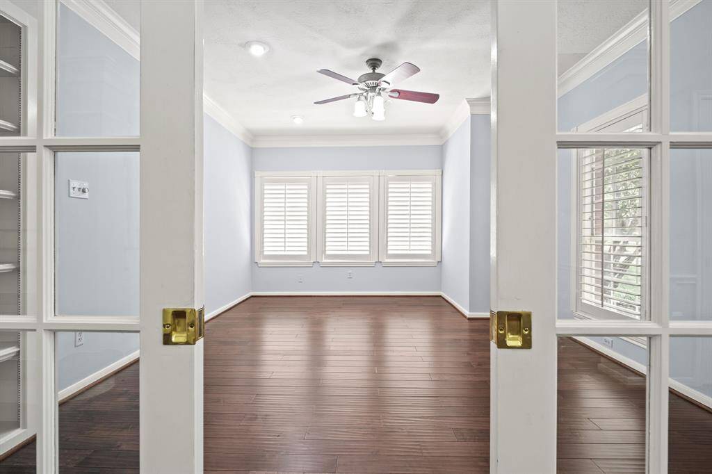 A spacious home office at the front of the home features custom glass pocket doors that slide closed to provide sound-barrier privacy without sacrificing natural light.
