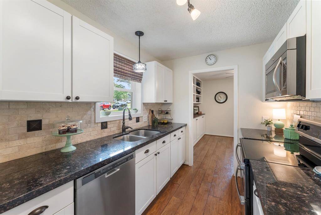 The stainless steel sink is positioned under the window that lets in natural light.