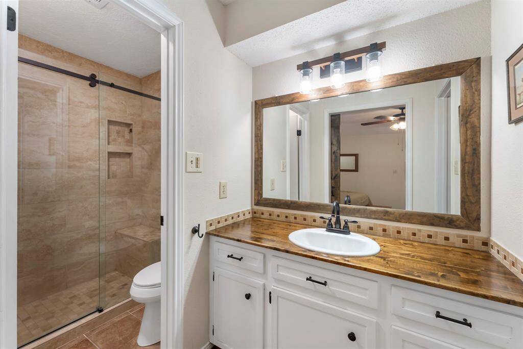 The primary bath has separate vanity and shower/toilet areas.