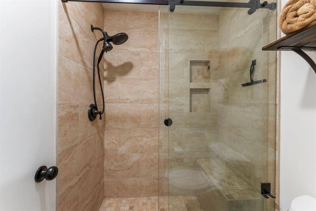 The walk-in shower is equipped with two niches and a bench.