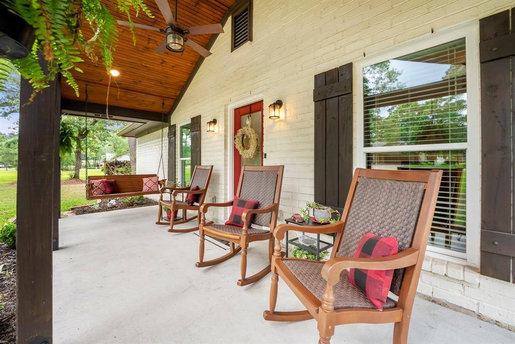 The extended front porch accommodates multiple chairs and a swing.