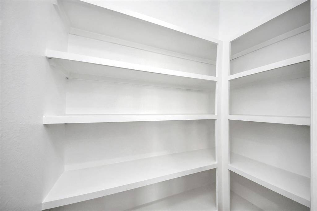 This walk-in pantry offers a practical and well-organized space with ample shelving and plenty of storage. Its generous size makes it easy to keep kitchen essentials neatly arranged and within reach, adding both function and convenience to the heart of the home.