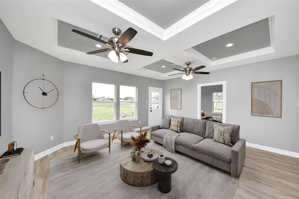 The spacious family room is bathed in natural light streaming through expansive windows, creating a bright and welcoming atmosphere. With its open layout and ample space, this inviting area is perfect for gathering with loved ones or unwinding after a long day - virtually staged.