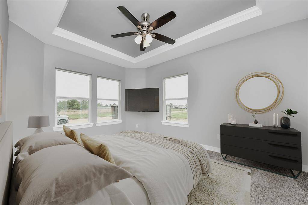 Step into the stunning primary suite, a spacious retreat designed for both comfort and style, offering plenty of room for all your favorite bedroom furniture. Flooded with natural light from large windows, this serene space is elevated by elegant crown molding, a sophisticated tray ceiling, and a stylish ceiling fan - virtually staged.