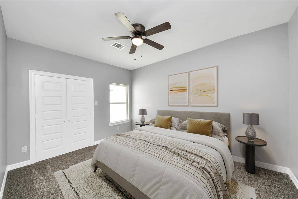 This cozy secondary bedroom exudes warmth with a large window that fills the space with natural light, neutral-toned walls for timeless appeal, a spacious closet for ample storage, and plush carpeting for added comfort - virtually staged.