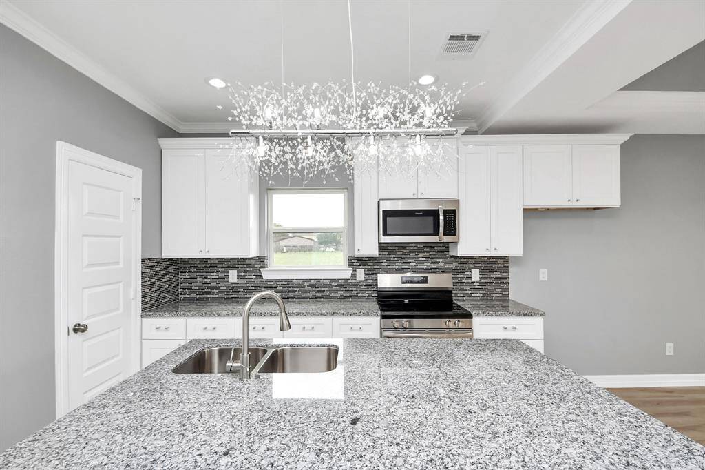 At the heart of the home, this stunning kitchen is a chef’s dream, featuring custom soft-close cabinetry, gleaming granite countertops, a spacious island with bar seating, and top-of-the-line stainless steel appliances for a perfect blend of style and functionality.