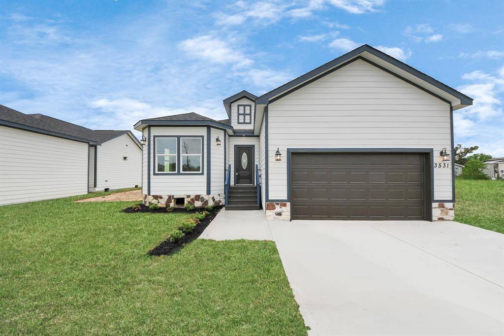 This newly built home features a clean and modern exterior with a striking front elevation that combines subtle architectural details with a neutral color palette. The well-maintained landscaping adds to its curb appeal, with neatly trimmed shrubs and a fresh lawn.