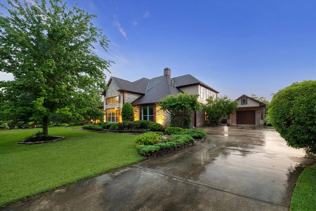 A sweeping driveway welcomes you home, leading to a spacious two-car attached garage and an additional detached one-car garage—perfect for extra vehicles, hobbies, or storage.