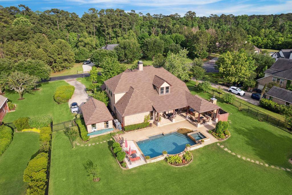 Aerial view of 36927 Anglers Way highlights the spacious backyard with pool, spa, and covered patios, all surrounded by lush landscaping and tucked within the privacy of a gated community.