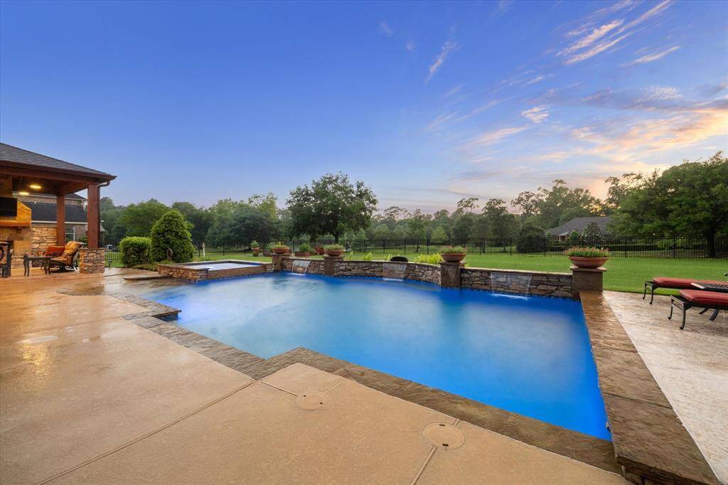 Enjoy serene views of the heated pool and spa, set against a backdrop of open green space and a tranquil lake. Nearby, a raised-bed garden with dedicated irrigation grows blueberries, blackberries, sweet potatoes, and Meyer lemons. Mature beds include herbs, perennials, and a variety of fruit and ornamental trees—guava, peach, plum, red oak, maple, and birch—bringing seasonal color and natural beauty to this private retreat.