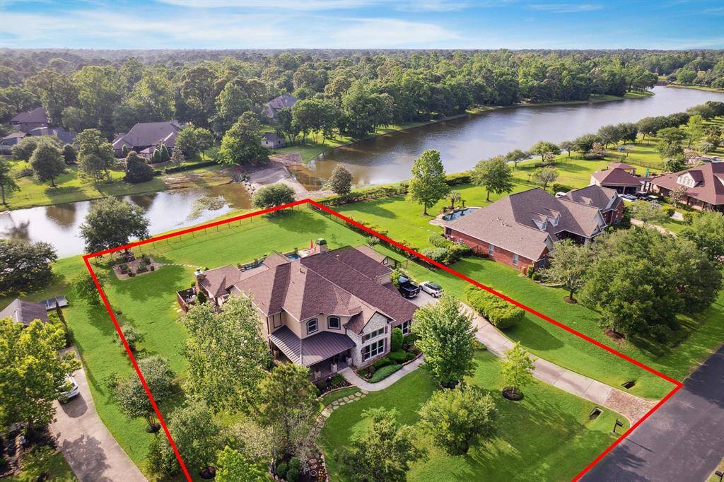 Alternate aerial view of 36927 Anglers Way showcasing the expansive, fenced backyard with direct lake views. This prime waterfront setting offers privacy, green space, and a peaceful backdrop within the gated community of Old Mill Lake.