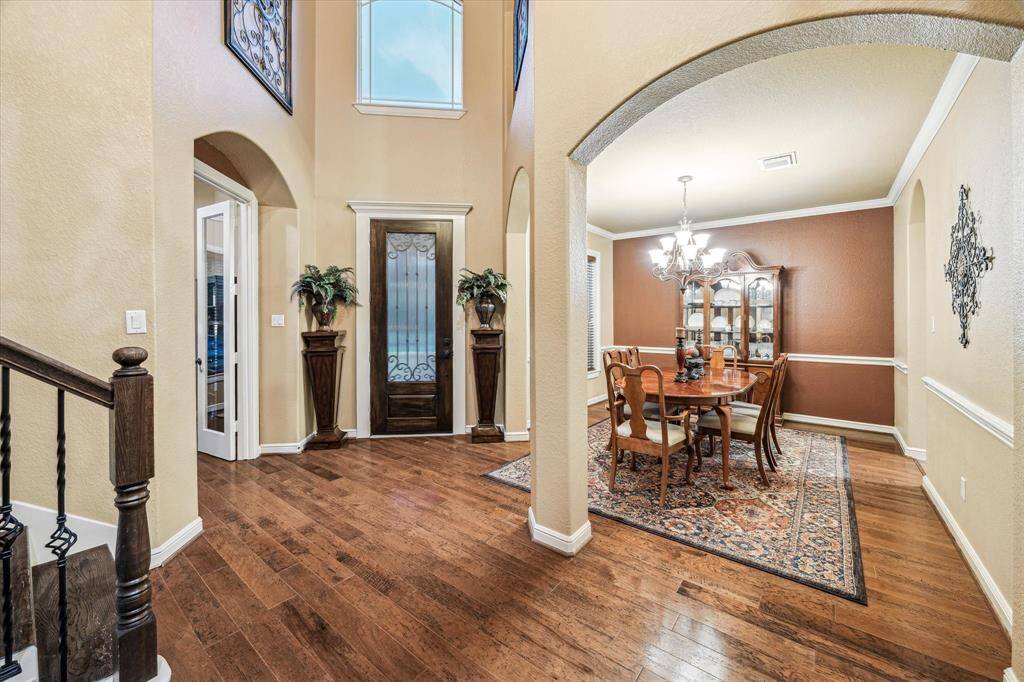 This inviting dining room space features warm wall tones, crown molding, and chair rail detailing—perfect for hosting gatherings in a refined, comfortable setting. Natural light enhances the welcoming ambiance throughout.